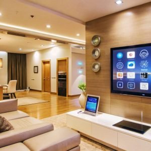 Modern living room interior with a large TV screen displaying a home automation system.